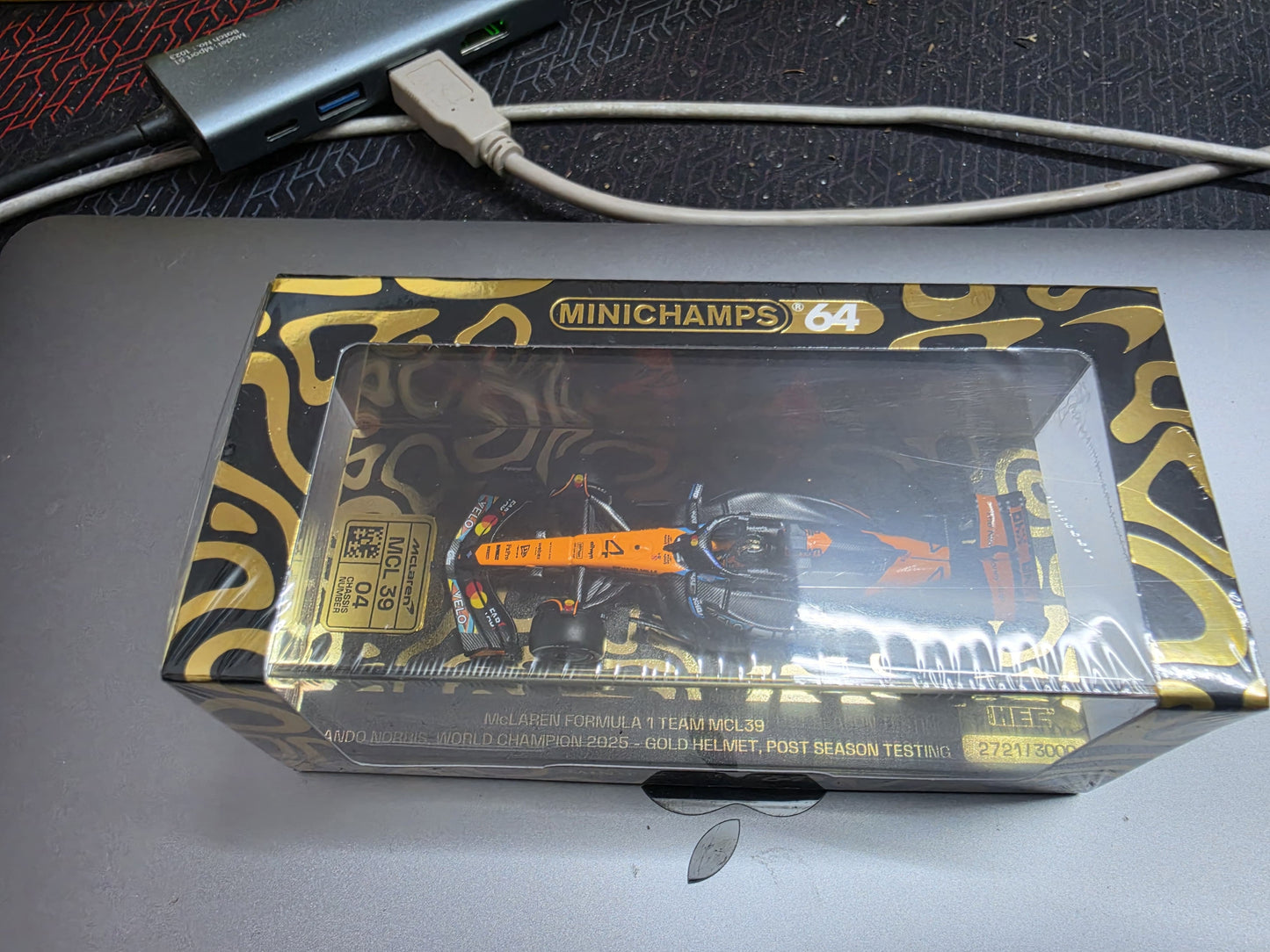 Mini Champs 64 : Mclaren Formula 1 Team MCL39 Lando Norris World Champion 2025 Gold Helmet Numbered Limited edition HEC Exclusive Black Box